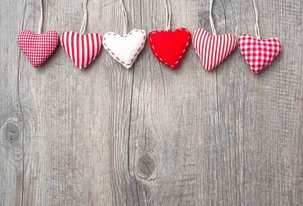 Red hearts hanging over wood background — Stock Photo, Image