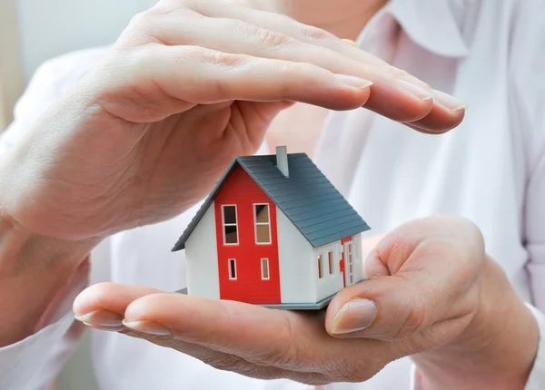 Huis in menselijke handen — Stockfoto