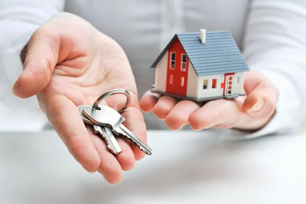 Agent with house model and keys — Stockfoto