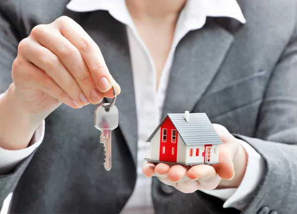 Zakenvrouw met huis model en sleutels — Stockfoto