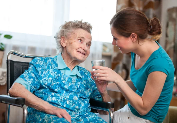 Mulher idosa com cuidador doméstico — Fotografia de Stock