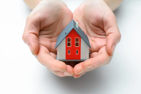 Huis in menselijke handen — Stockfoto