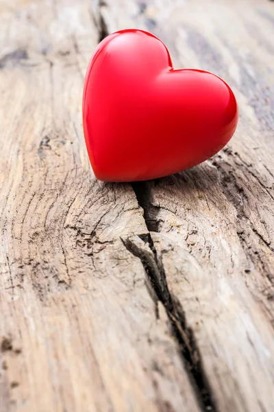 Red heart in crack of wooden plank — Stock Photo, Image