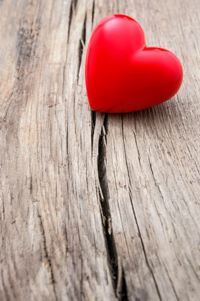 Corazón rojo en la grieta de tablón de madera — Foto de Stock