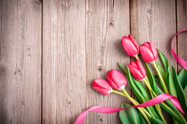 Tulipas rosa em fundo de madeira — Fotografia de Stock