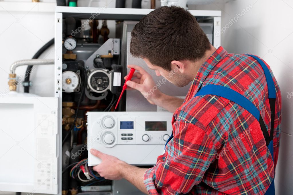 Technician servicing heating boiler