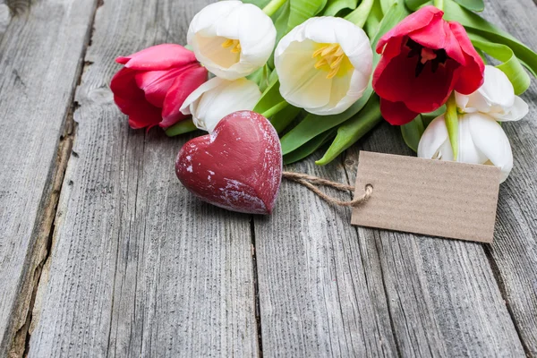 Tulipas frescas e coração vermelho com uma etiqueta — Fotografia de Stock