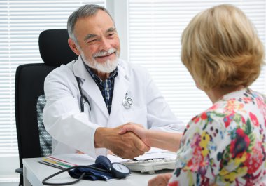 Doktor hastaya el sallayarak