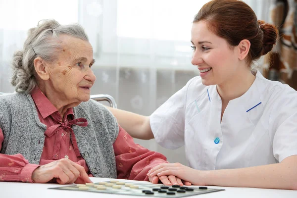 Senior vrouw spelen van dammen — Stockfoto