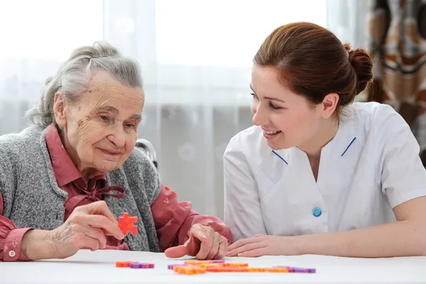 Seniorin mit ihrer Altenpflegerin — Stockfoto