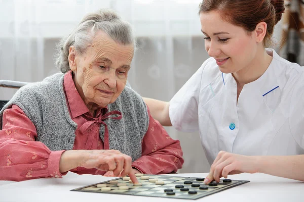 Senior mulher jogando damas — Fotografia de Stock