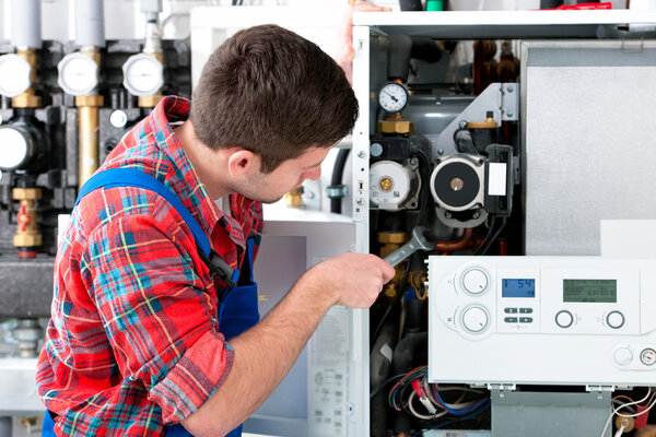 Technician servicing heating boiler