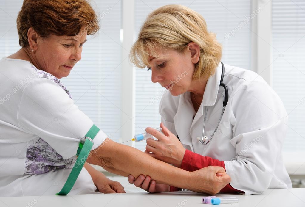 Doctor with syringe is taking blood for test