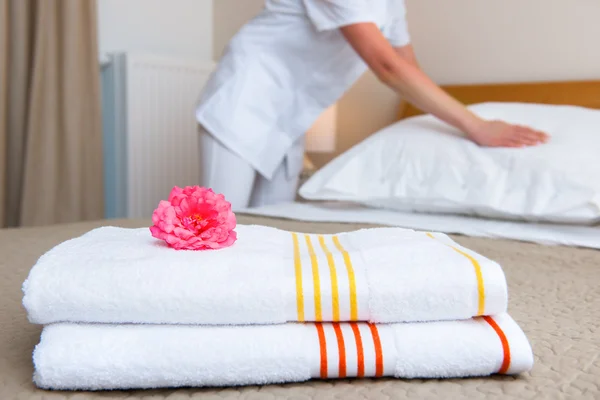 Empregada fazendo cama no quarto de hotel — Fotografia de Stock