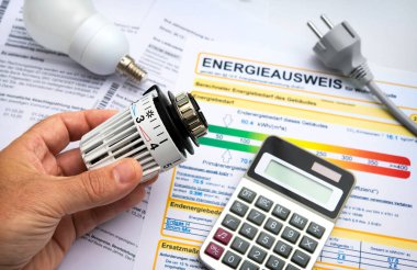 Enerji konsepti, modernleşme yoluyla enerji tasarrufu. Radyatör termostatı, hesap makinesi ve enerji sertifikasıyla el.