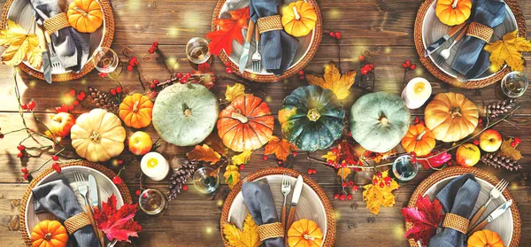 感謝祭や他の家族のお祝いを祝うための秋の装飾テーブル ガラス製品 カボチャ バラのヒップの枝と木のテーブルの背景の葉を持つ祭りのテーブル設定 トップビュー — ストック写真