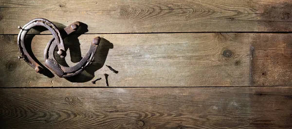 素朴な木製の背景に幸運の魅力の象徴として2つの古い錆びた馬の靴 — ストック写真