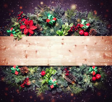 Düz, köknar dalları, böğürtlenler, koniler, noktalı çiçekler ve koyu arkaplanda hediye kutuları olan kış Noel kompozisyonu uzanıyordu. Metin için alanı kopyala