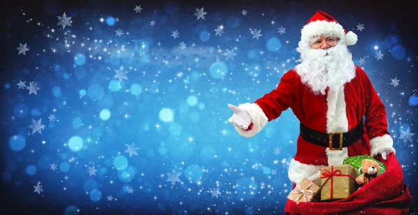 Санта Клаус Сумкой Полной Подарков Синем Снежном Фоне Волшебными Звездами — стоковое фото