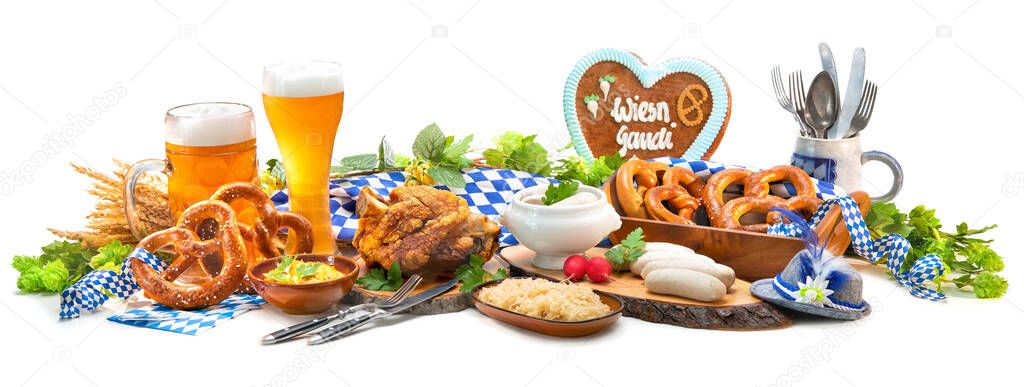 Festive served table with Bavarian specialities. Sausages, pork knuckle,  pretzels, sweet mustard and beer mugs isolated on white. Oktoberfest menu