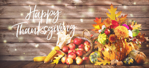 Счастливого Дня Благодарения. Украшение Дня Благодарения тыквами, букетом цветов, фруктами и опадающими листьями на деревенском деревянном столе