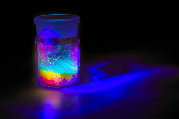 Materiales orgánicos fluorescentes de color rojo, amarillo y verde para la producción OLED dentro de la botella de vidrio en luz UV . Fotos De Stock
