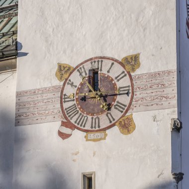 Seefeld, Tyrol, Avusturya 'da parlak kış ışığında çekilen tarihi St. Osvald Parrish kilisesinin çan kulesindeki süslü duvar saatinin ayrıntıları.,