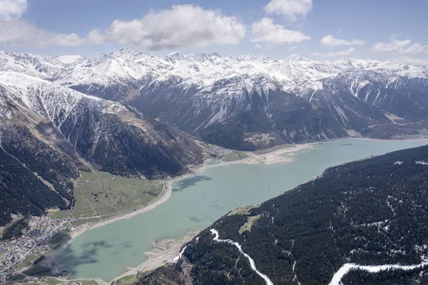 aerial shot, from a small plane, of  Curon mountain village on Resia lake, shot on Venosta valley in bright spring light, Bolzano, Alto Adige, Ital