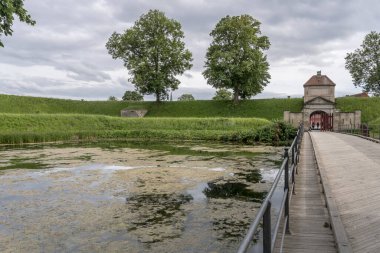 Danimarka, Kopenhag 'da, Kopenhag' da parlak bulutlu bir ışıkta çekilen, Kastellet kalesinin üzerinde köprü ve Norge kapısı bulunan şehir manzarası.