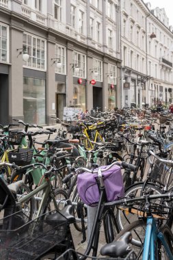Copenhagen, 2022 june 14 , a heap of bicycles parked in central street among old buildings, shot in bright light on 2022 june 14 at Copenhagen, Denmark