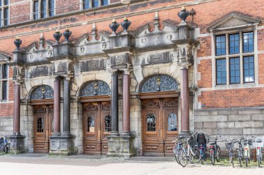 cityscape with bicycles parked at monumental entrance of historical Railway Station, shot in bright sunlight at Helsingor, Denmark