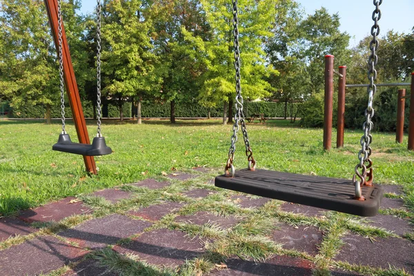 Качели на детской площадке — стоковое фото