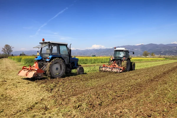 Tractors plowing a field — Stock Photo, Image