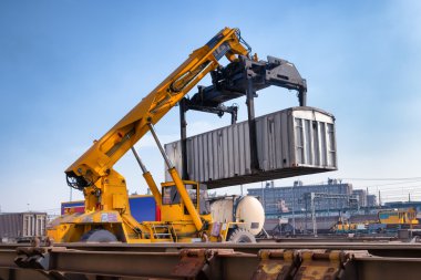 Crane lifts a container loading a train clipart