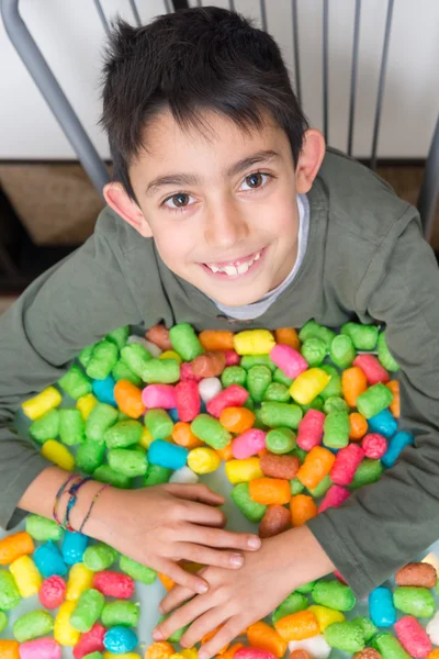 Улыбающийся ребенок играет с красочными кукурузными игрушками — стоковое фото