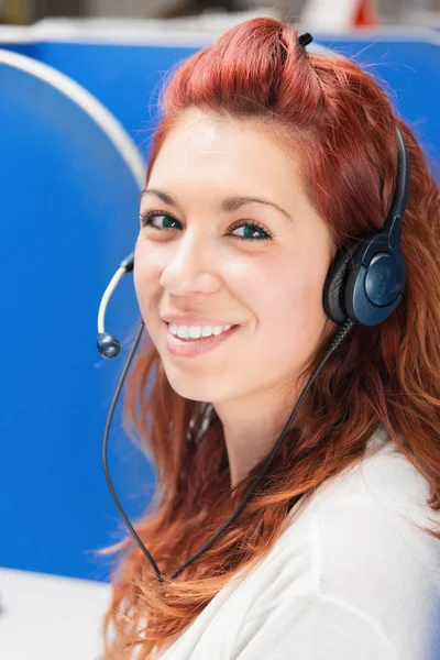 Hermosa joven operador de centro de llamadas femenino con auriculares en la oficina — Foto de Stock