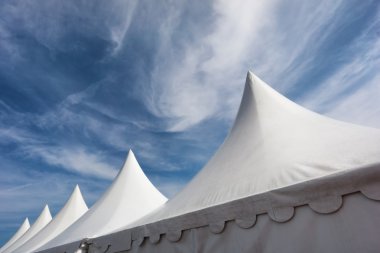 rij van witte evenement en Partytenten tegen blauwe hemel