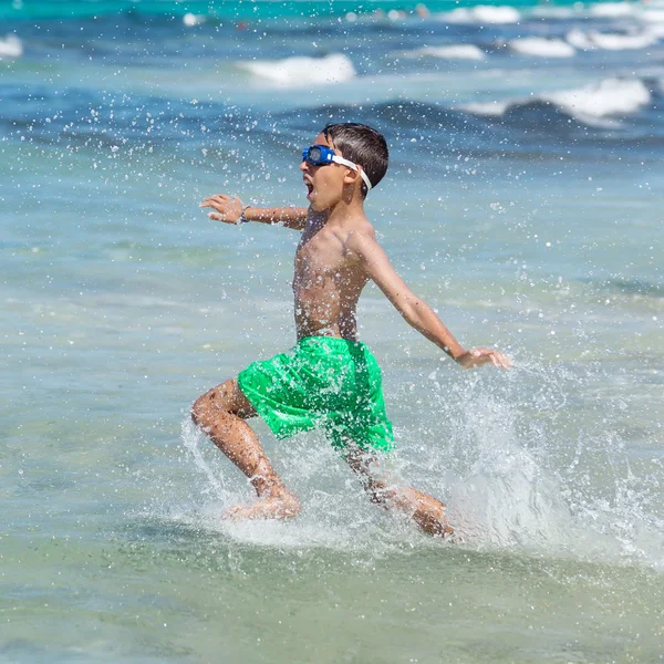 Niño corriendo por el agua en la playa —  Fotos de Stock