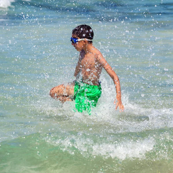 Salpicaduras de niños saltando al mar en la playa —  Fotos de Stock