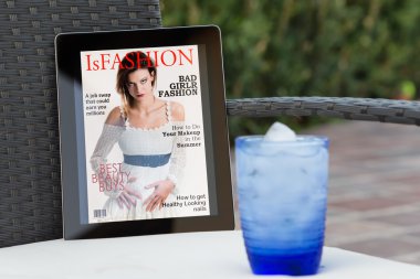 bahçede bir tablet üzerinde sahte moda dergi kapağı