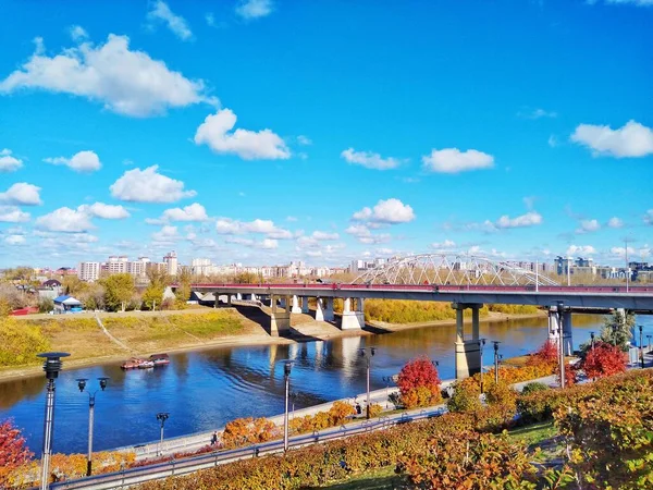 川の上に橋で川で秋の都市 秋の晴れた日 白い雲と青い空 — ストック写真