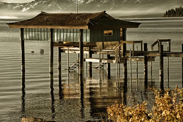 Gólyaláb kunyhóban egy tó — Stock Fotó