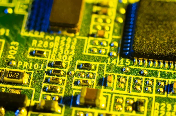 Old electronic circuit board close up in macro photography, yellow lighting