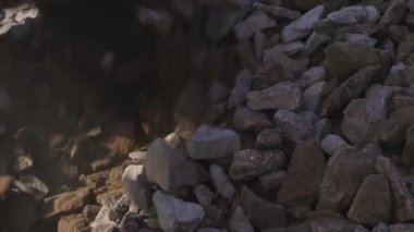 Bir kürek yakın planda moloz yükler. Harç ve beton karıştırmak için özel ezilmiş taş