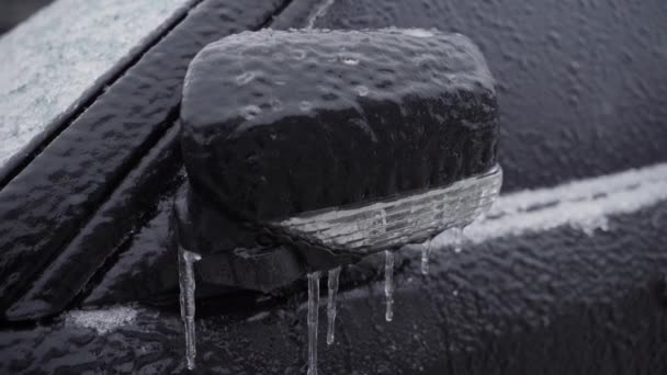 Espejo lateral plegado del coche, primer plano helado. El coche está cubierto de hielo después de la lluvia helada en temperaturas bajo cero. — Vídeos de Stock