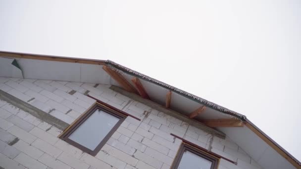 Goła fasada i niedokończony dach domu przed mglistym niebem — Wideo stockowe