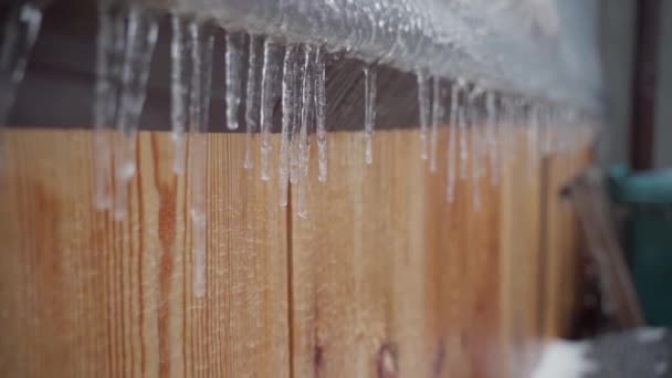 Icicli appesi in inverno su una struttura in legno primo piano — Video Stock