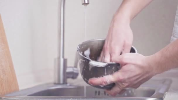 手は流しの中の鋳鉄製の釜を洗い、洗剤から水ですすいでください。 — ストック動画