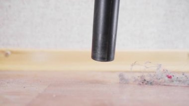Yakın plan çekimde elektrik süpürgesinin namlusundan toz bulutları düşer. Toprak ve tozun oluşumu