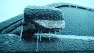 Katlanmış araba aynası buz saçakları ile kaplanmış. Şiddetli dondurucu soğuk ve dondurucu yağmurdan sonra soğuk.